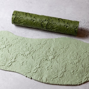 Könnte beinhalten: Ein Set aus drei Keramikbechern mit gesprenkelter, matter Oberfläche. Die Becher sind in Creme-, Hellgrau- und Dunkelgrautönen gehalten. Jede Tasse hat ein schlichtes, minimalistisches Design.