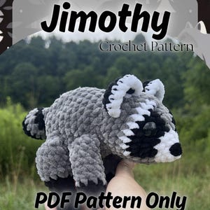 May include: A crochet pattern for a plush raccoon named Jimothy. The pattern is a PDF document featuring a gray, black, and white stuffed raccoon toy with a striped tail, black paws, and a masked face. The text reads Jimothy Crochet Pattern.