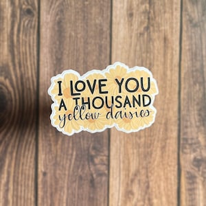 May include: A sticker with yellow daisies surrounding the text "I love you a thousand yellow daisies".