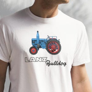 May include: White t-shirt with a blue and red tractor illustration and the text "LANZ Bulldog" printed on the front.