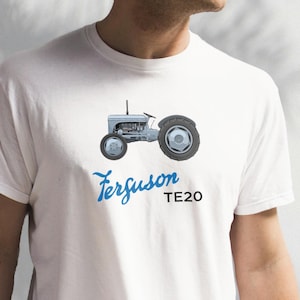 May include: White t-shirt with a blue illustration of a gray Ferguson TE20 tractor. The text "Ferguson TE20" is printed in blue below the tractor.
