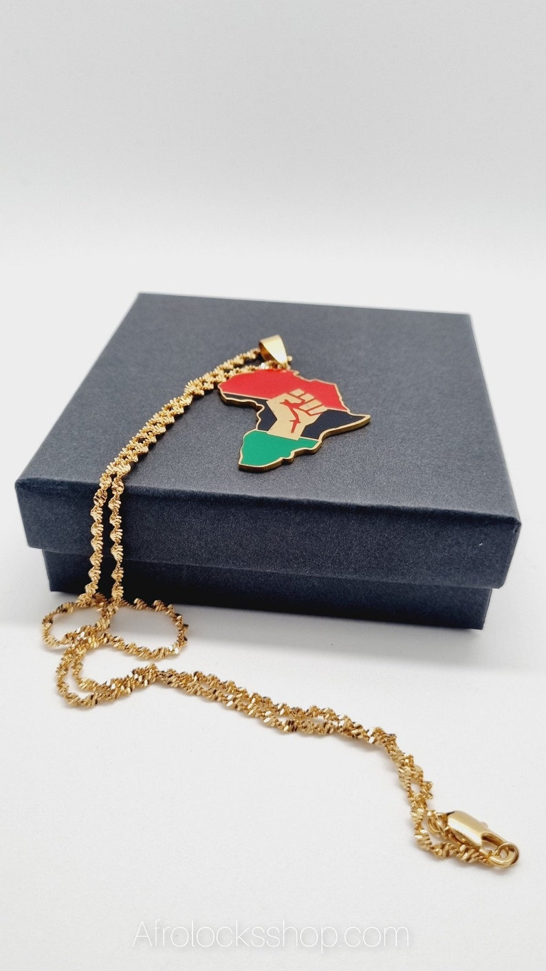 K&ouml;nnte beinhalten: Goldkette mit einem Anh&auml;nger in Form des afrikanischen Kontinents. Der Anh&auml;nger ist rot, gr&uuml;n und schwarz mit einer erhobenen Faust in der Mitte.