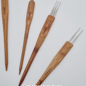 Może przedstawiać: Cztery drewniane szydełka z ostrymi końcówkami. Każde szydełko jest oznaczone "0.5mm".