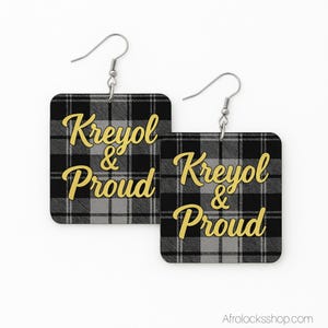 Peut inclure: Boucles d'oreilles carrées à motif écossais noir et gris. Les boucles d'oreilles portent l'inscription "Kreyol & Proud" en lettres dorées. Les boucles ont des crochets argentés.
