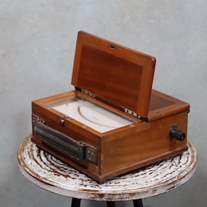 Hermoso instrumento de medición antiguo, vintage, voltímetro de la marca Carpentier en caja de madera original con asa de tela.