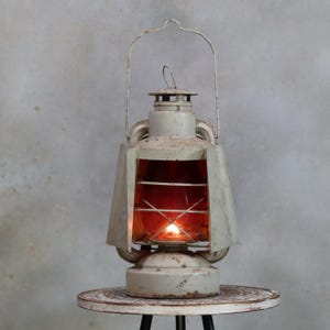 Old ALG storm lamp, storm lantern, French storm lamp in vintage condition, with protective cover with glass with red paint, still largely present.