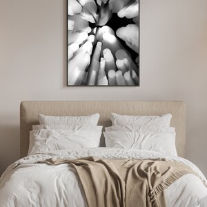 May include: Black and white abstract photograph of a blurred, circular pattern. The image is taken from a low angle, looking up at a series of round objects.