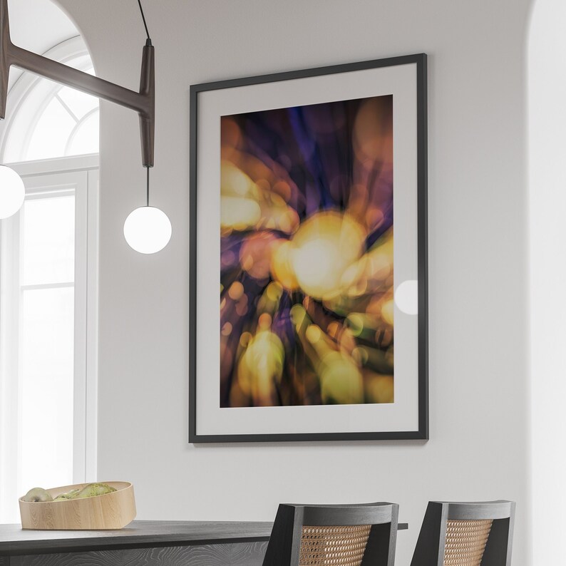 May include: Abstract art print in a black frame with a blurred background of yellow, green, purple, and blue colors.