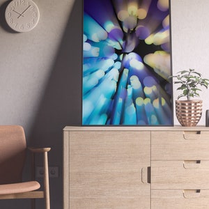 May include: A framed abstract art print with a blue, purple, and yellow color scheme. The print features a blurred, circular pattern of light.
