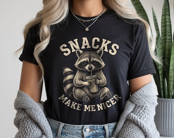 Camiseta de mapache con el lema "Los snacks me hacen más amable", camiseta vintage de animales, camiseta con meme divertido, ropa con frases sarcásticas sobre comida.