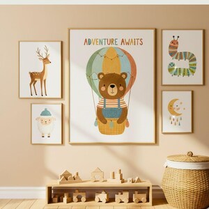 Puede incluir: Un conjunto de láminas enmarcadas para la habitación infantil. Las láminas representan un ciervo, una oveja, una oruga, una luna y un oso en globo aerostático. La lámina central dice "Adventure Awaits".