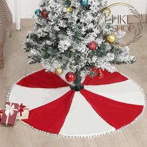 May include: Red and white candy cane striped Christmas tree skirt with white pom pom trim.