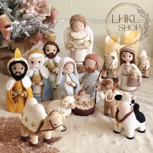 Pode incluir: Um presépio de crochê com figuras de Maria, José, o menino Jesus, um anjo, três reis magos, um camelo, um burro e ovelhas. As figuras estão todas vestidas com roupas tradicionais e estão dispostas em círculo ao redor do presépio.