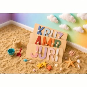 May include: Three rectangular wooden name puzzles featuring colorful cutout letters with small wooden knobs for grasping. The puzzles display the names KRIZ, AMIR, and JURI in various pastel and bold colors, arranged in a stack on a sandy surface.
