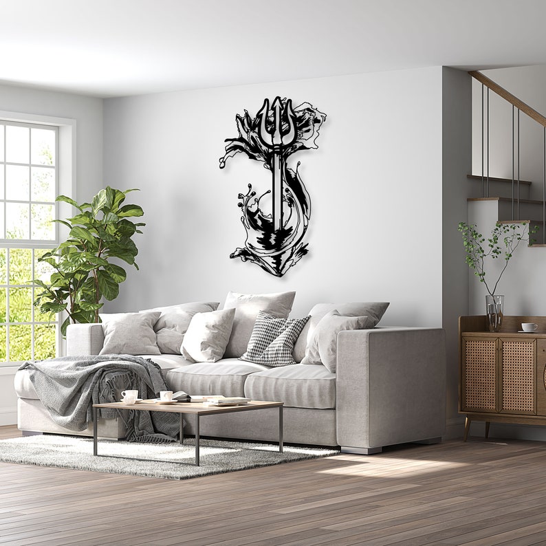 May include: Black metal wall art depicting a trident with waves crashing around it. The art is mounted on a white wall in a living room setting.