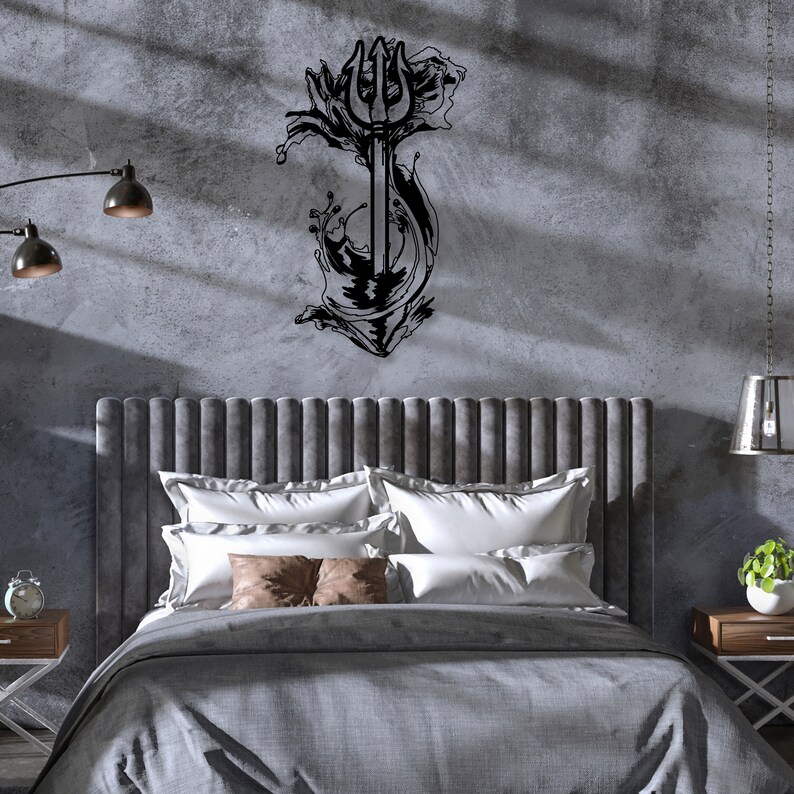 May include: A black metal wall decor featuring a trident with stylized waves. The decor is mounted on a gray concrete wall above a gray upholstered headboard with white and brown pillows.