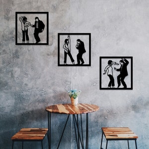 May include: Three black and white silhouette wall art pieces depicting a couple dancing. The art pieces are framed in black and hung on a gray concrete wall. A wooden table with a black metal frame sits in front of the wall art.