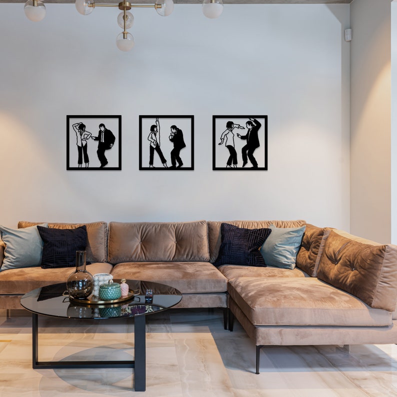 May include: Three black and white silhouette wall art pieces depicting a couple dancing. The art is framed in black and hung on a white wall above a brown sectional sofa.