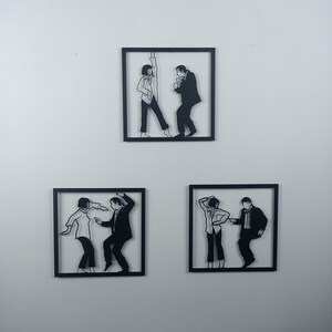 May include: Three black and white silhouette wall art pieces depicting a couple dancing. The art pieces are framed in black and mounted on a white wall.