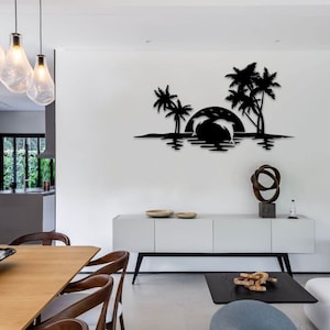 May include: Black metal wall art depicting a tropical scene with palm trees, a setting sun, and two dolphins jumping out of the water. The art is mounted on a white wall in a modern living room.