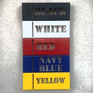 May include: Five metal rectangular signs with different colors and the words "BLACK", "WHITE", "RED", "NAVY BLUE", and "YELLOW" cut out of the metal.