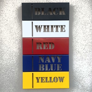 May include: Five metal rectangular signs with different colors and the words "BLACK", "WHITE", "RED", "NAVY BLUE", and "YELLOW" written in white.