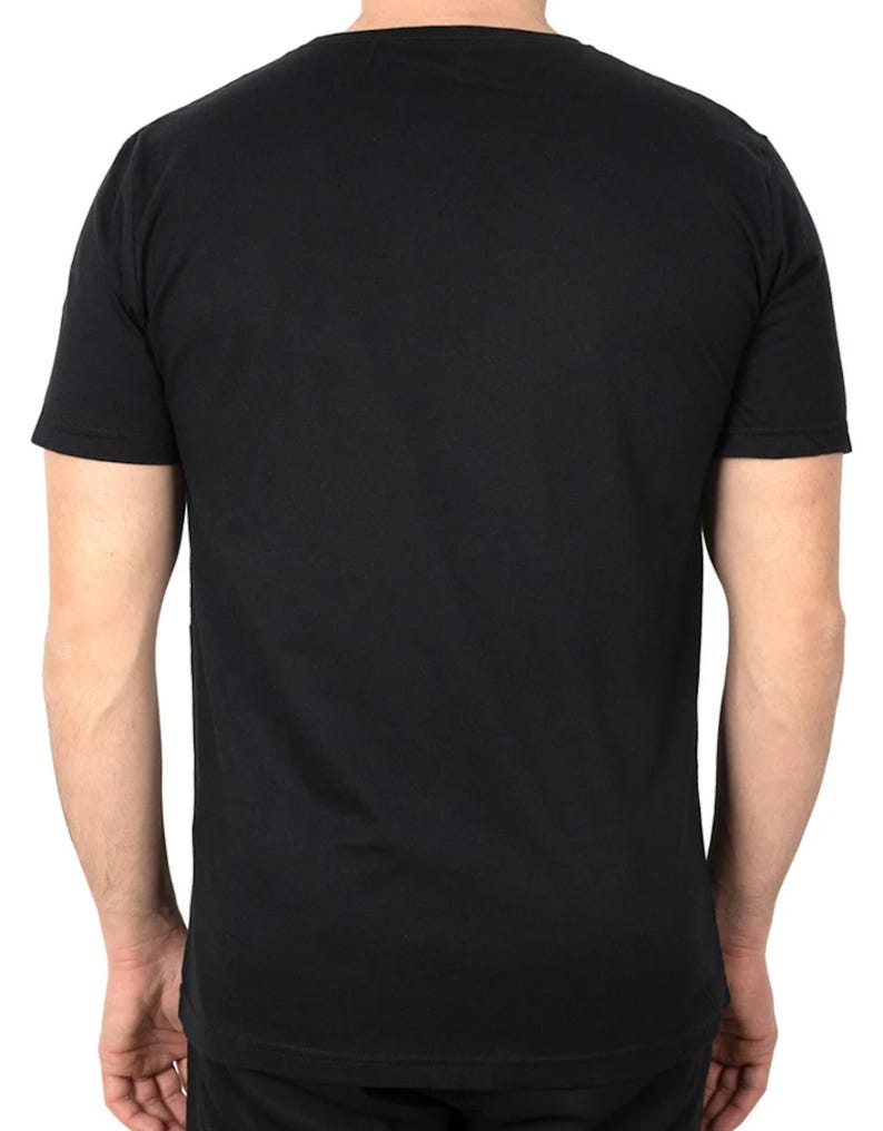 May include: A black crew neck t-shirt with short sleeves. The back of the shirt is visible, showing the shoulders and upper back. The shirt is made of a soft, opaque material.