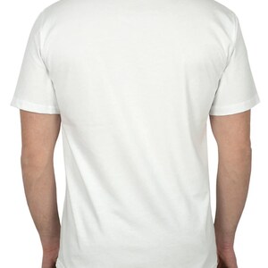May include: A plain white short-sleeve t-shirt. The back of the shirt is visible, showing the neckline and the sleeves. The shirt is made of a soft, opaque fabric.