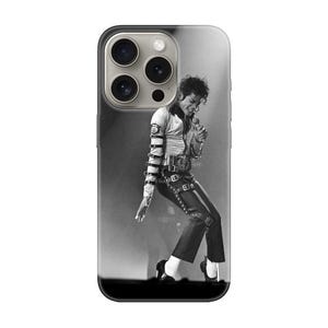 Puede incluir: Funda de teléfono en blanco y negro con una fotografía de Michael Jackson actuando en el escenario. La imagen muestra a Jackson con camisa blanca, pantalón negro y zapatos negros, a mitad de baile. La funda tiene un borde negro y un acabado brillante.