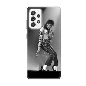 May include: Monochrome phone case depicting a performer on stage. The image shows the performer in a dynamic pose, holding a microphone. The phone case has a black border and a camera cutout. The image is in shades of grey.