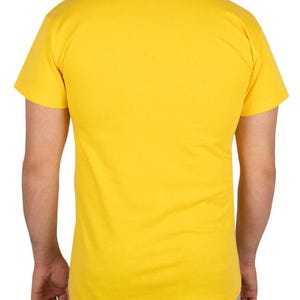 May include: A solid yellow t-shirt with a crew neck and short sleeves. The back view of the shirt is shown, with the shoulders and upper torso visible. The shirt is made of a soft, likely cotton material.