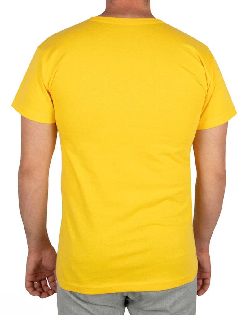 May include: A solid yellow t-shirt with a crew neck and short sleeves. The back view of the shirt is shown, with the shoulders and upper torso visible. The shirt is made of a soft, likely cotton material.