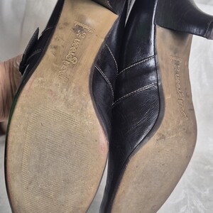 May include: Pair of black leather heeled shoes with a buckle closure. The soles are worn and show the brand name "Paul Green". The heels are approximately 2.5 inches high.