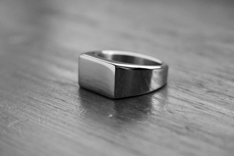 May include: A silver signet ring with a rectangular top.