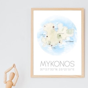 Könnte beinhalten: Gerahmte Aquarellkarte von Mykonos, Griechenland, mit markierten Schlüsselorten. Die Karte ist vor einem hellblauen Aquarellhintergrund platziert. Das Wort "MYKONOS" und Koordinaten sind darunter gedruckt.