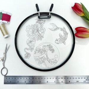 May include: A round embroidery hoop with a black frame, featuring a dragon, koi fish, and wave design. Includes embroidery floss, scissors, and a 12-inch ruler. Red and yellow tulips are also present.