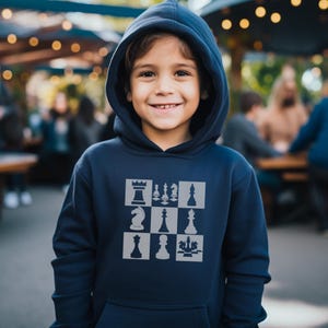 May include: A navy blue hooded sweatshirt with a chessboard design featuring the different chess pieces in gray.