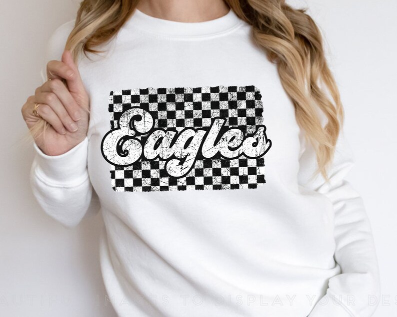 May include: White sweatshirt with a black and white checkered design and the word "Eagles" in a retro font.