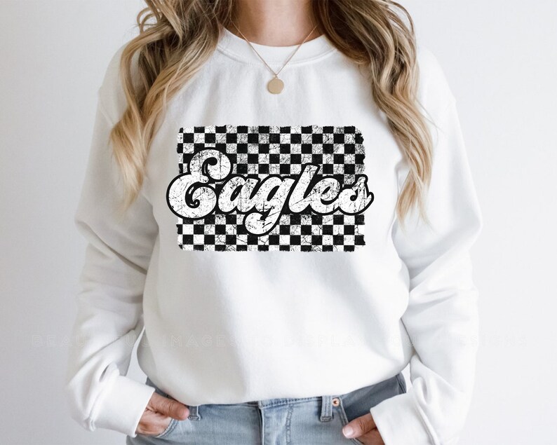 May include: White sweatshirt with a black and white checkered design and the word "Eagles" in a retro font.