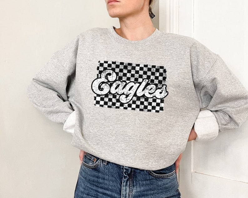 May include: Gray sweatshirt with a black and white checkered design and the word "Eagles" in a retro font.