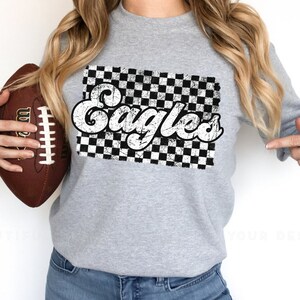 May include: Gray sweatshirt with a black and white checkered design and the word "Eagles" in a retro font.