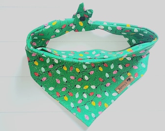 May include: Green bandana with a white string of Christmas lights pattern. The bandana has a brown tag with the text "Benny's" on it.