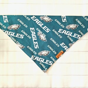 May include: Green and white dog bandana with a repeated pattern of the Philadelphia Eagles logo and the word "Eagles".