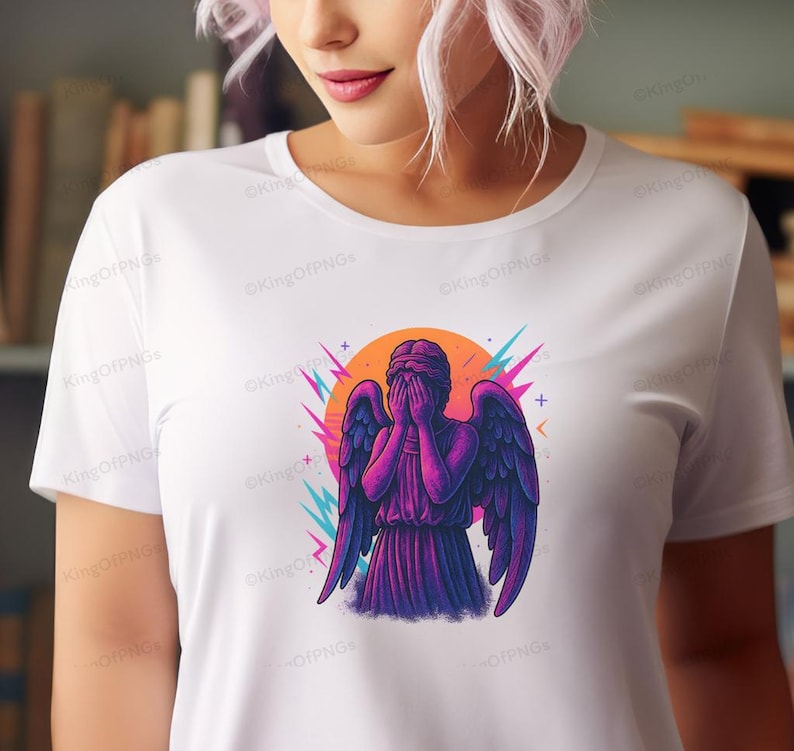 A woman wearing a white t-shirt with a graphic design of an angel with purple and blue wings.