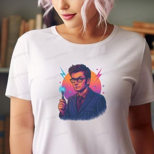 A woman wearing a white t-shirt with a colorful illustration of a man holding a futuristic-looking device.