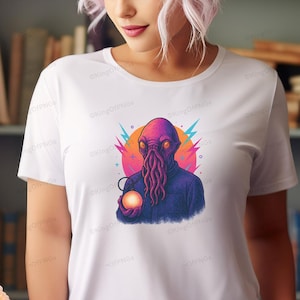A woman wearing a white t-shirt with a colorful graphic of an alien-like creature holding a glowing orb.