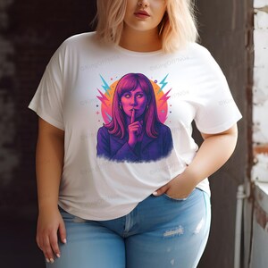 A woman wearing a white t-shirt with a colorful graphic of a woman with long hair and a purple jacket.