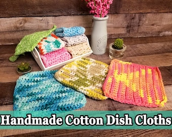 May include: A selection of handmade cotton dishcloths in a variety of colours and patterns, including green, blue, pink, yellow, and orange. The dishcloths are shown on a white tray and a wooden surface.