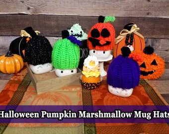 Könnte beinhalten: Eine Sammlung von Halloween-Marshmallow-Tassenhüten in verschiedenen Farben, darunter Schwarz, Grün, Orange und Lila. Die Hüte sind gehäkelt und sollen Kürbissen ähneln. Das Bild enthält auch dekorative Kürbisse und einen Cupcake.