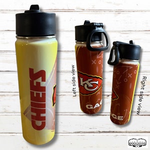 May include: A stainless steel water bottle with a black lid and handle. The bottle features the word "CHIEFS" in red on a yellow and white background. The right side of the bottle has a red background with a football play design and the team logo.